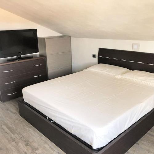 a bedroom with a bed and a flat screen tv at Appartamento L’Angelica in Assemini