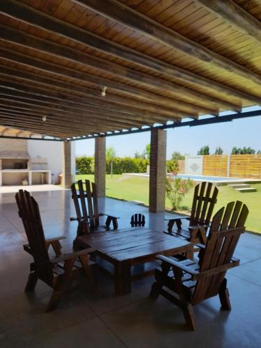 Une table et des chaises en bois sont disponibles sur la terrasse. dans l'établissement Cabañas El Kincho, à Albardón
