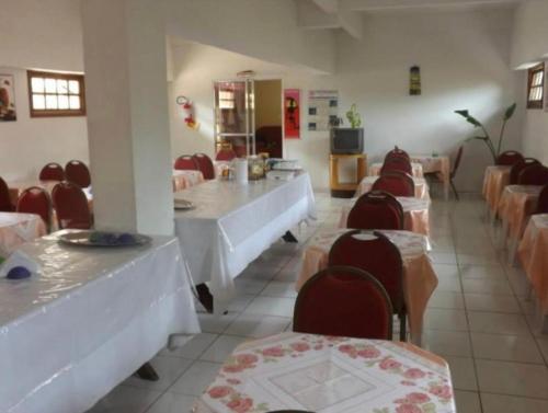 ein Restaurant mit Tischen und Stühlen und ein Zimmer mit Tischen und Stühlen in der Unterkunft Hotel Morada de Leste in Pontal do Paraná