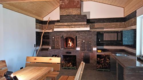 a large stone fireplace in a room with a table and chairs at Rancho Resort in Bilichi