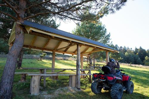 a red atv parked under a shed next to a tree at Rancho Resort in Bilichi