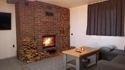 a living room with a brick fireplace and a table at Rancho Resort in Bilichi
