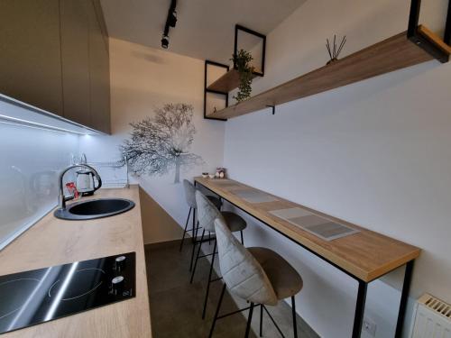 a kitchen with a sink and a counter with stools at Studio Apartman Golden Lux 1 in Pale