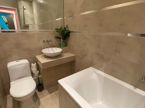 een badkamer met een bad, een toilet en een wastafel bij Boutique Dungeon in Brighton & Hove