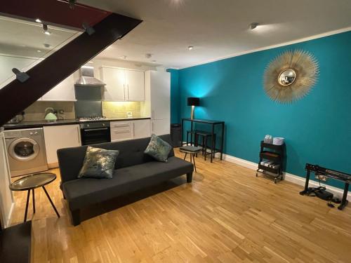 a living room with a couch and a blue wall at Boutique Dungeon in Brighton & Hove