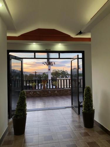 a lobby with an open door with two plants at Departamentos Bonsai in Torreón