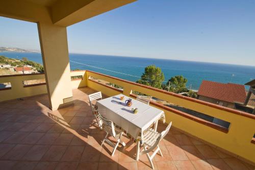 a table and chairs on a balcony with the ocean at Holiday Beach Lumia in Sciacca