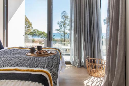 Un dormitorio con una cama con una bandeja de comida. en IKIES 3 Modern Eco-Friendly Private Seaview SIGNATURE Villas with a Pool, en Volos