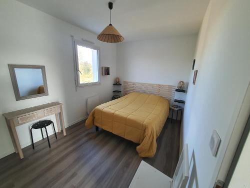 een slaapkamer met een bed met een gele deken bij LA PETITE SALAMANDRE des Conches in Longeville-sur-Mer