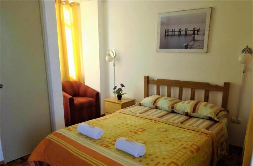 a small bedroom with a bed and a chair at Icthus Paracas in Paracas