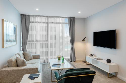 a living room with a couch and a tv at Meriton Suites Sussex Street, Sydney in Sydney