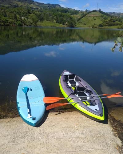 two boats are parked on the shore of a lake at Glamping Montecarlo Lodge Cubo de Madera-Guatapé in Guatapé