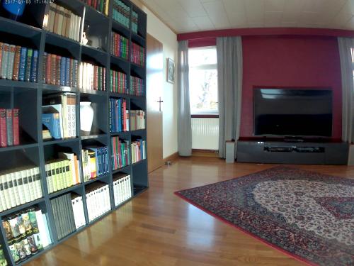 una sala de estar con una estantería llena de libros en Ferienwohnung Eppendorf, en Eppendorf