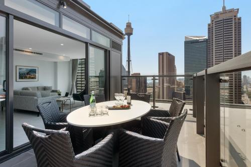 a patio with a table and chairs on a balcony at Meriton Suites Sussex Street, Sydney in Sydney
