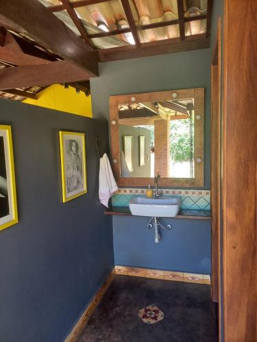a bathroom with a sink and a mirror at Casa Jabuticaba Refúgio e Hospedagem in São Miguel Arcanjo