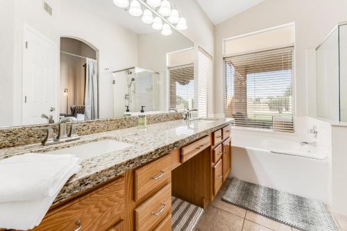 uma casa de banho com 2 lavatórios e um espelho grande em Pura Vida em Goodyear