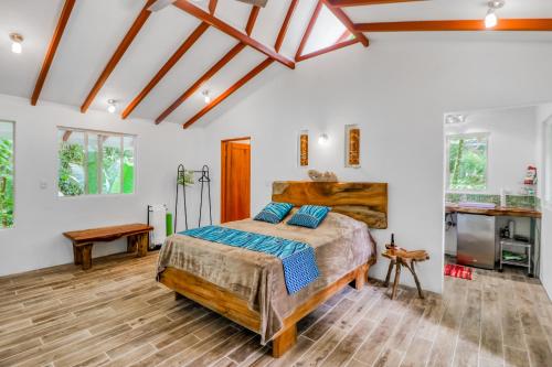 a bedroom with a king sized bed and wooden floors at Lost Pools Bungalow #Sloth in Uvita