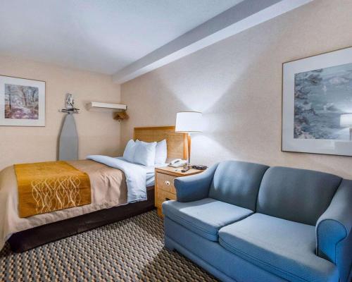 een hotelkamer met een bed en een bank bij Rodeway Inn Saint John in Saint John