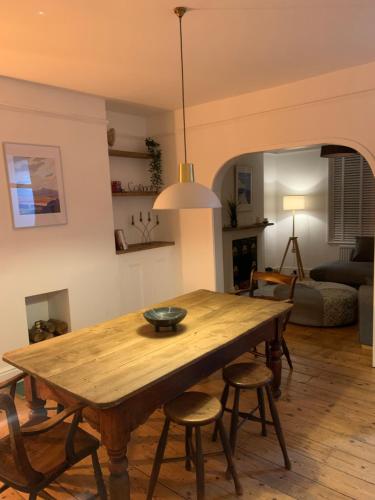 een eetkamer met een houten tafel en stoelen bij White Heather Terrace in Bovey Tracey