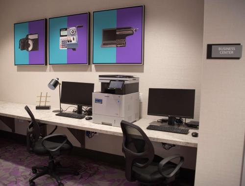 an office with two computers on a desk with chairs at Best Western Premier Winnipeg East in Winnipeg