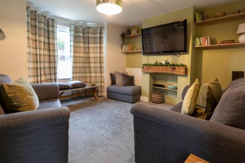 a living room with two couches and a flat screen tv at Belmont in Southampton