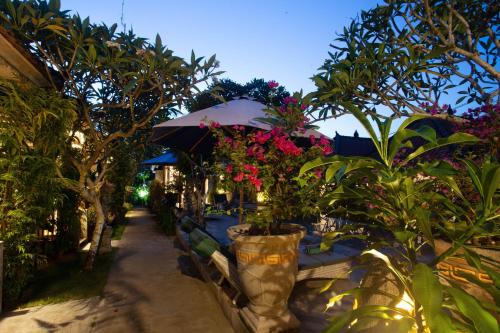 a patio with a bunch of flowers and plants at 221 Garden Cottages in Nusa Lembongan