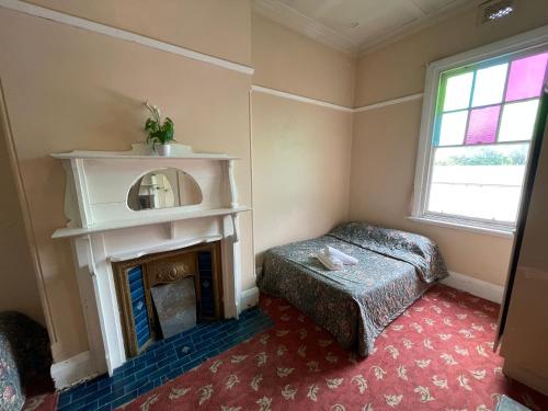 a bedroom with a fireplace and a bed and a window at Royal Hotel Motel Scone in Scone