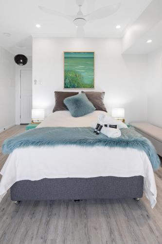 a bedroom with a large bed with a blue blanket at Studio on Morgo over looking the ocean and rivers in Urunga