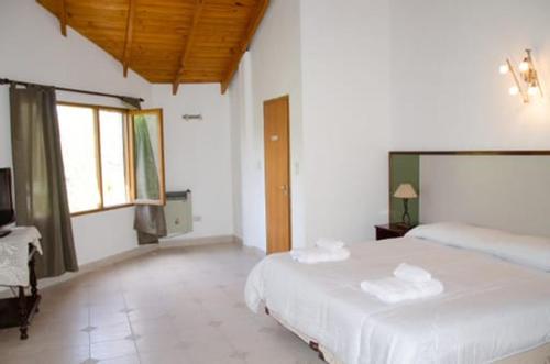 喬斯馬拉爾的住宿－Hosteria La Farfalla，一间卧室配有两张床和电视。