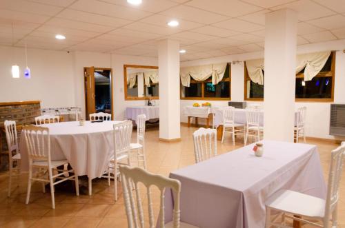 喬斯馬拉爾的住宿－Hosteria La Farfalla，一间设有白色桌椅的用餐室