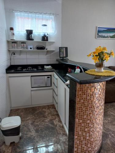 Il comprend une cuisine équipée d'une cuisinière et d'un comptoir. dans l'établissement Casa da piscina, à Arraial do Cabo