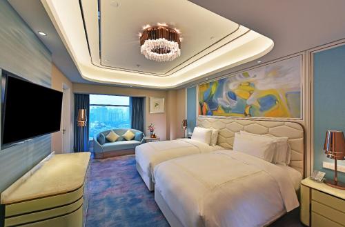 a hotel room with two beds and a television at Radisson Collection Hotel, Xing Guo Shanghai in Shanghai