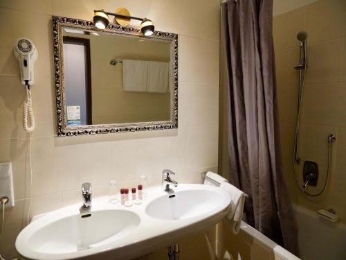 a bathroom with a sink and a mirror at Hotel Endorfer Hof in Bad Endorf