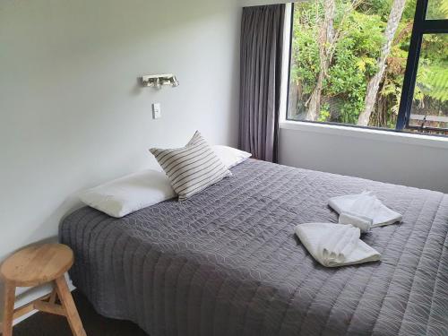 a bedroom with a bed with two pillows and a window at Bay Vista Waterfront Motel in Picton
