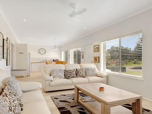 a living room with a white couch and a table at Windspray in Culburra Beach
