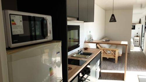 a kitchen with a microwave on top of a counter at Casa Container Chacra 202 in Tandil