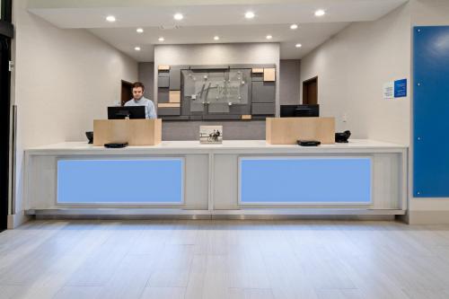 a woman standing behind a counter with boxes at Holiday Inn Express Hotel & Suites Atascadero by IHG in Atascadero