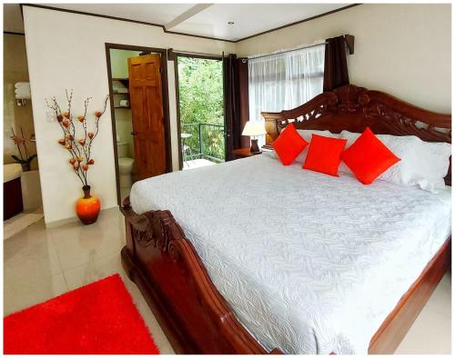 a bedroom with a large bed with red pillows at Dreams Lodge in Monteverde Costa Rica