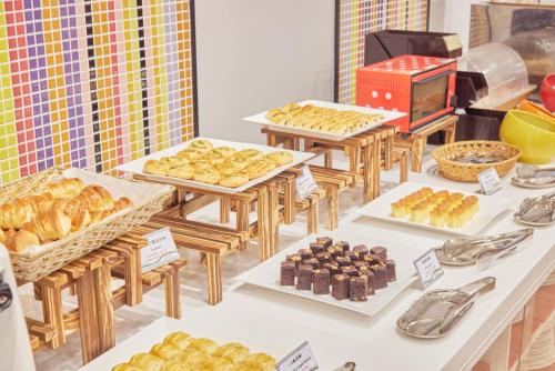 een buffet met zoete deegwaren en andere zoete deegwaren op een tafel bij Uni-Resort Ku-Kuan in Heping