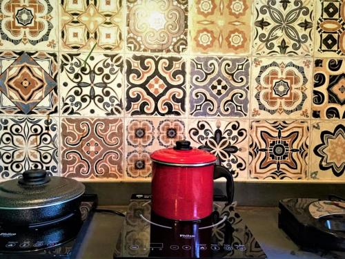 a red coffee pot sitting on top of a stove at Vila Hibisco Itacaré in Itacaré