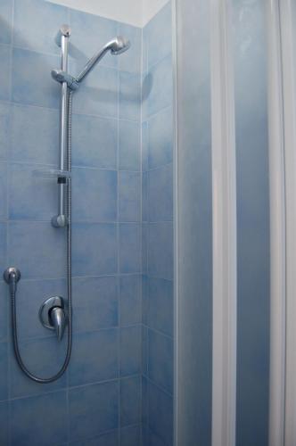 a shower in a bathroom with blue tiles at Borgo Valmarina in Follonica