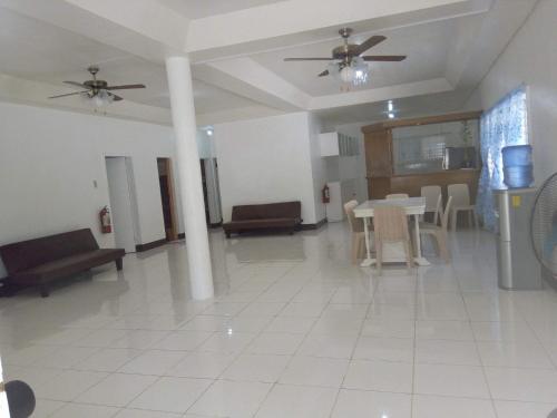 a large living room with a table and chairs at Luna Oslob Travellers Inn in Oslob