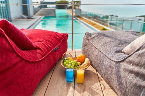 a bowl of fruit and two glasses of juice on a balcony at JN PARK Hotel in Incheon