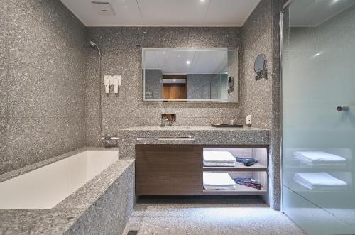 a bathroom with a tub and a sink and a mirror at JN PARK Hotel in Incheon