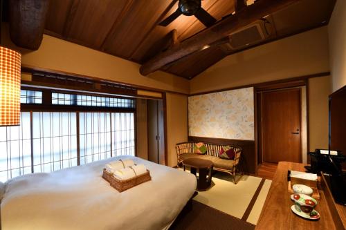 a bedroom with a large bed and a living room at Muromachi Yutone Kyokoyado in Kyoto