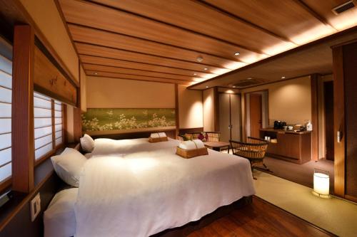 a bedroom with a large white bed in a room at Muromachi Yutone Kyokoyado in Kyoto