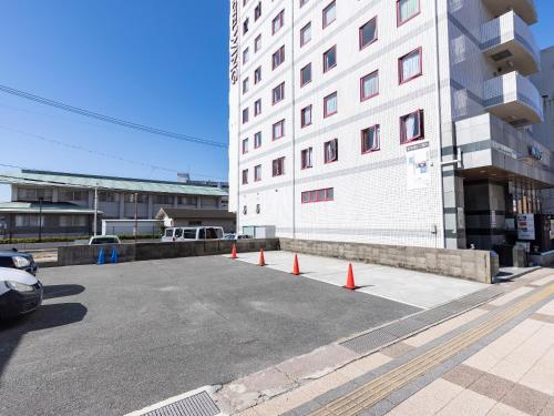 a parking lot with orange cones in front of a building at Hotel Wing International Shimonoseki in Shimonoseki