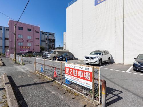 a car parked in a parking lot next to a building at Hotel Wing International Shimonoseki in Shimonoseki