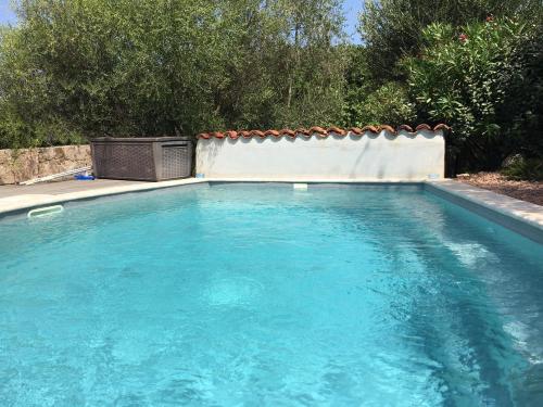 une piscine avec de l'eau bleue dans une cour dans l'établissement Le moulin de Figari, à Figari