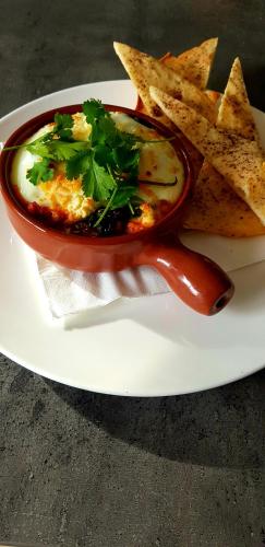 een wit bord met een kommetje eten en wat chips bij City Escape Taroona in Taroona